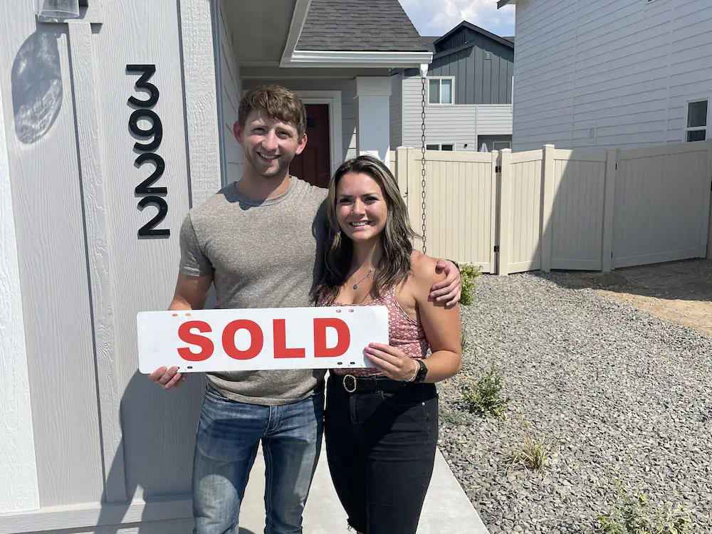 First-time Buyers with a sold sign in front of their brand new construction home in central Meridian.